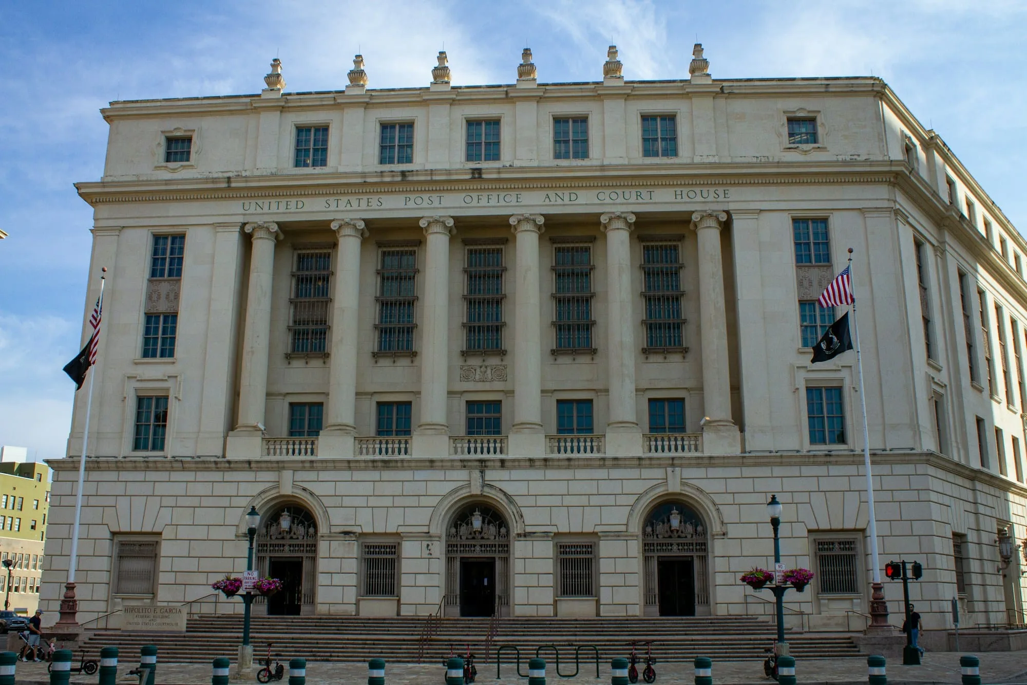 Neoclassical federal courthouse building with tall columns and flags on its facade